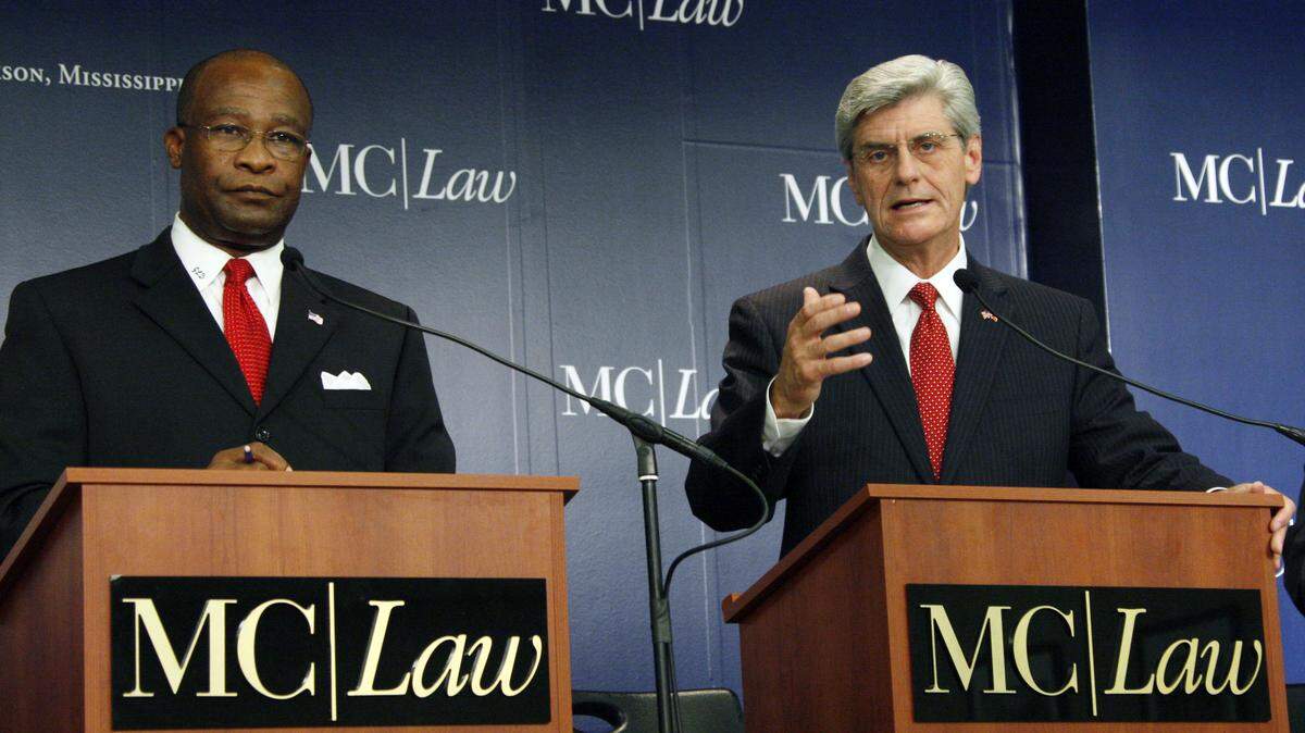 In this July 21, 2011 photo, Democrat Hattiesburg Mayor Johnny DuPree, left, listens as Republican Lt. Gov. Phil Bryant answers a reporter’s question during a gubernatorial debate at the Mississippi College School of Law auditorium in Jackson, Miss., prior to the primaries this summer. The two front runners face each other in a debate Friday, Oct. 14, 2011 in Jackson. (AP Photo/Rogelio V. Solis)