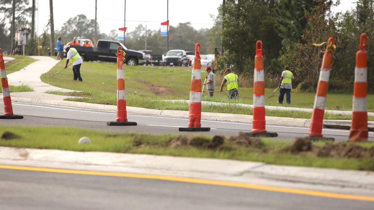 AMANDA McCOY/SUN HERALD 
 A construction crew finishes a roundabout at the intersection of Airport and Three Rivers roads on Monday, Nov. 16, 2015, in Gulfport. The roundabout is expected to open later this week.