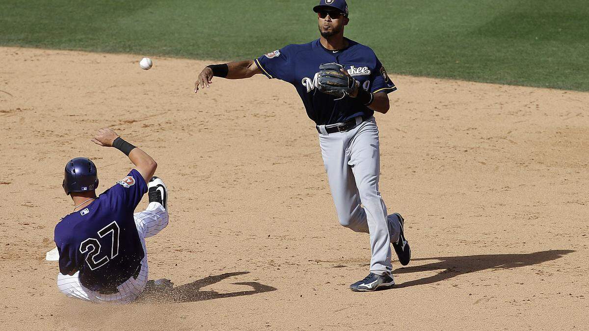 JEFF CHIU/ASSOCIATED PRESS 
 Milwaukee Brewers shortstop Yadiel Rivera, right, throws to first base after forcing out Colorado Rockies' Trevor Story (27) on a double play ball hit by Carlos Gonzalez Tuesday in Scottsdale, Ariz.