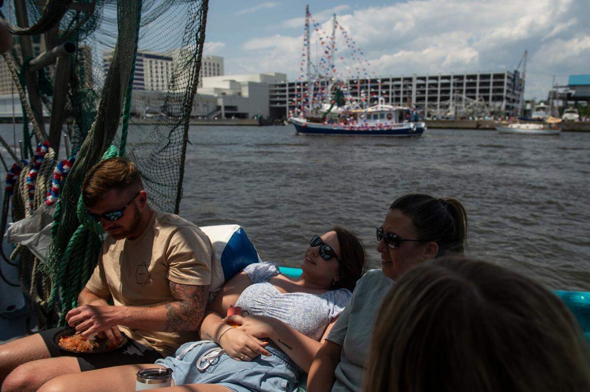 Family members of Shrimp King Wally Gollot sit on the edge of the Blessing Boat, My Sons, during the Blessing of the Fleet in Biloxi on Sunday, May 28, 2023.