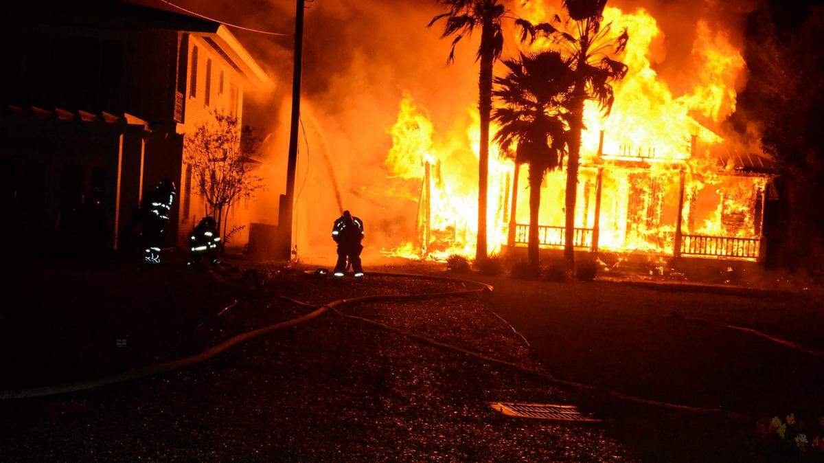 Dwayne Bremer/Sea Coast Echo 
 Firefighters battle a flaze that destroyed one home and damaged another on the 500 block of Beach Boulevard on Saturday, Nov. 21, 2015.
