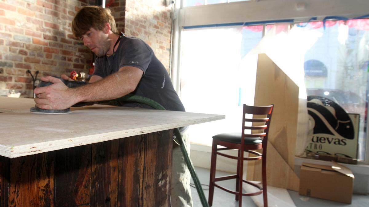 JOHN FITZHUGH/SUN HERALDNorman Cowand of Bay St. Louis sands a counter at the new location for Old Cuevas Bistro in Bay St. Louis on Monday Nov. 30, 2015.