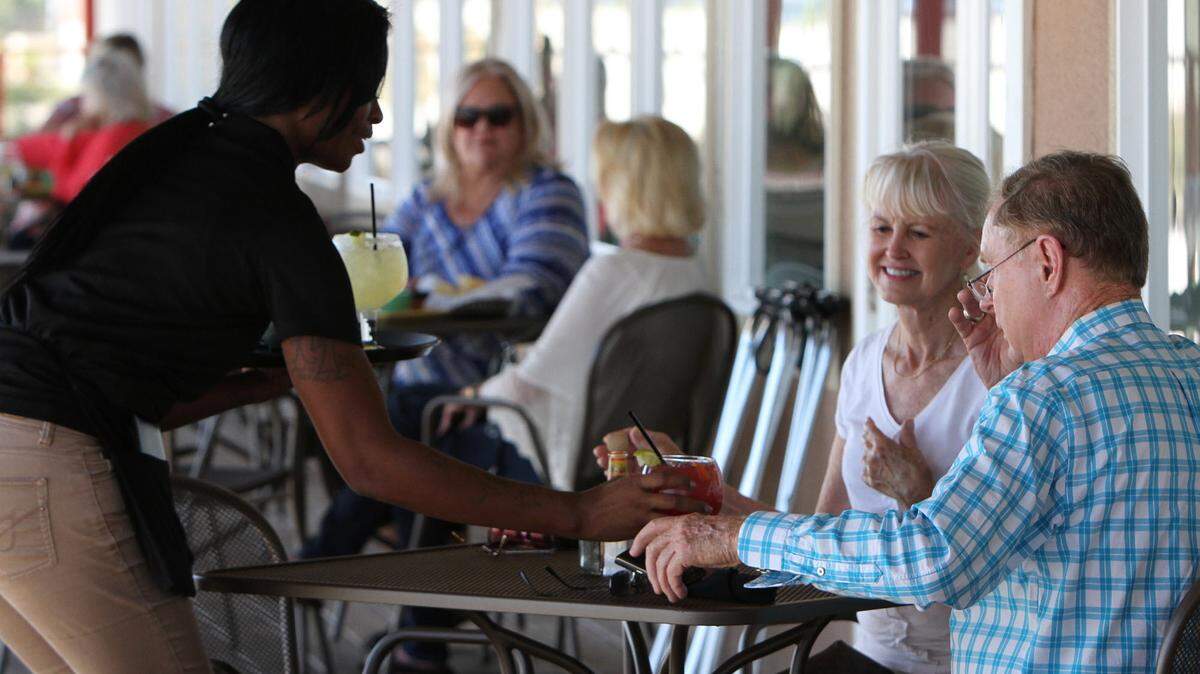 JOHN FITZHUGH/SUN HERALD 
 Waitress Kenosha Kelly of Biloxi serves Jackie Brown of Tuburon, Ca., and Bill Best of San Francisco at Baja Beach Biloxi Tex Mex restaurant in Biloxi on Thursday Oct. 1, 2015.