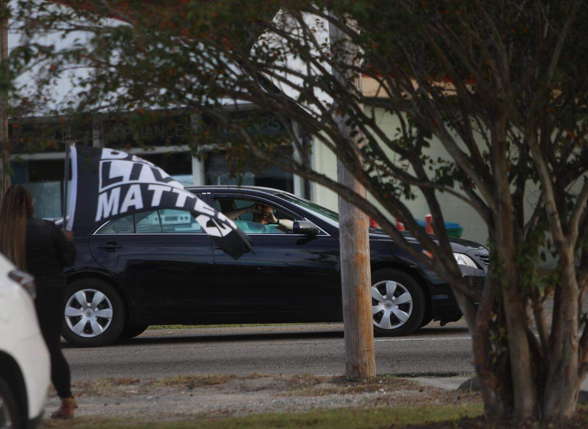 A driver stopped at a red light on Pass Road in Gulfport makes a heart sign with his hands in solidarity with protesters demanding justice for Jaheim McMillan, a 15-year-old shot and killed by Gulfport police.