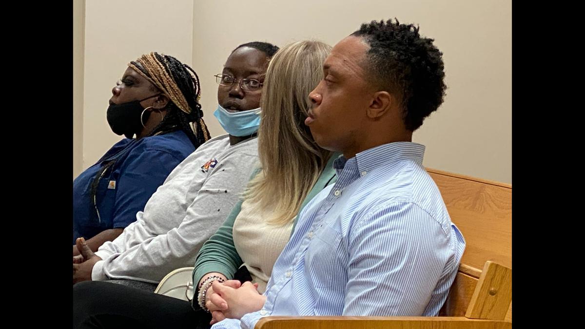 Ex-Moss Point Police Officer Eric Maye sits with family and friends prior to his appearance for a probable cause hearing that led to his arrest on an felony embezzlement charge.