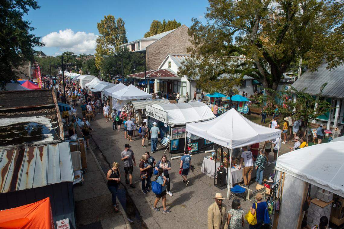 People walk among tents selling art along Government Street during the Peter Anderson Festival in Ocean Springs on Sunday, Nov. 6, 2022.