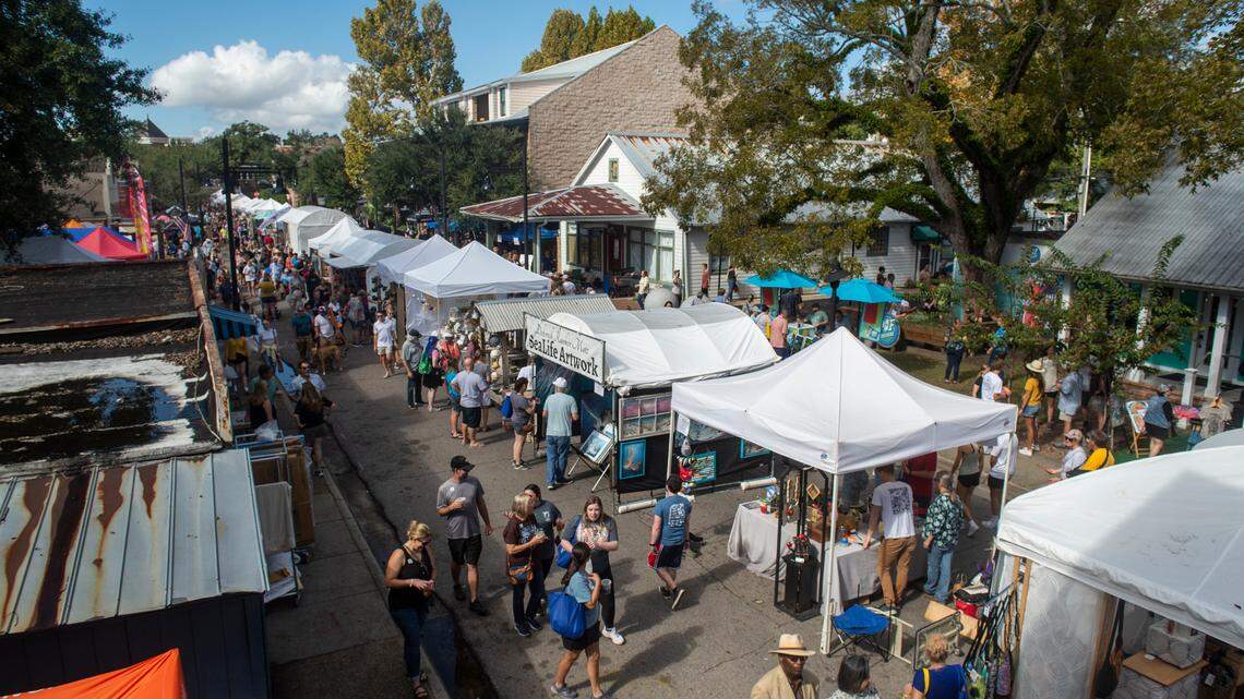 People walk among tents selling art along Government Street during the Peter Anderson Festival in Ocean Springs on Sunday, Nov. 6, 2022.