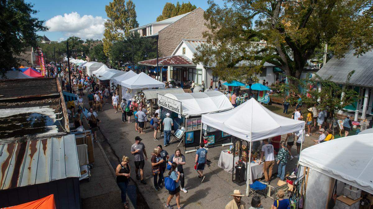 People walk among tents selling art along Government Street during the Peter Anderson Festival in Ocean Springs on Sunday, Nov. 6, 2022.