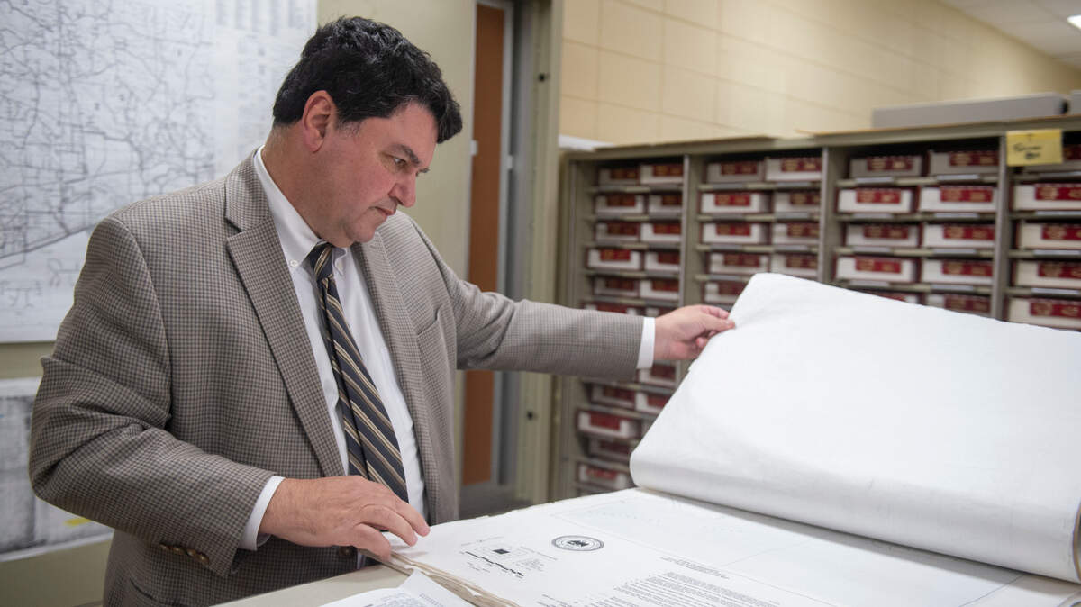Biloxi city attorney Peter Abide looks through maps of tidelands in the Chancery Clerk’s office in Biloxi on Monday, March 11, 2024. The state legislature is planning to pass a bill that would affect the control of the tidelands.
