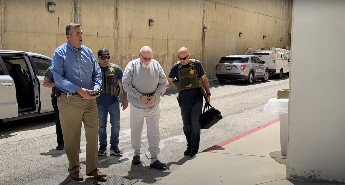 Warren Luther Alexander is escorted by law enforcement in August 2023 into the Ventura County jail, where he is being held after authorities charged him in three cold-case murders in Southern California.