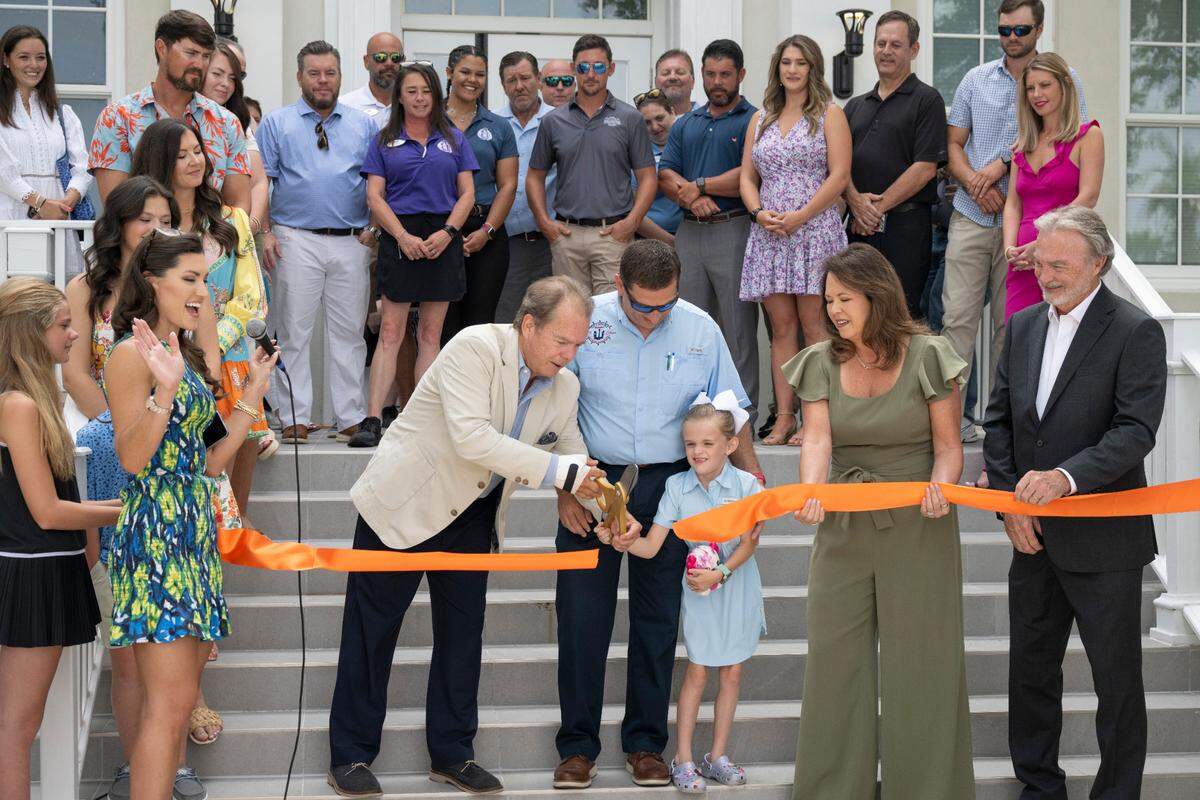 Gulfport Mayor Billy Hewes, center left, cuts the ribbon for the grand opening of Hippie Fish at Centennial Plaza in Gulfport on Thursday, June 26, 2025.