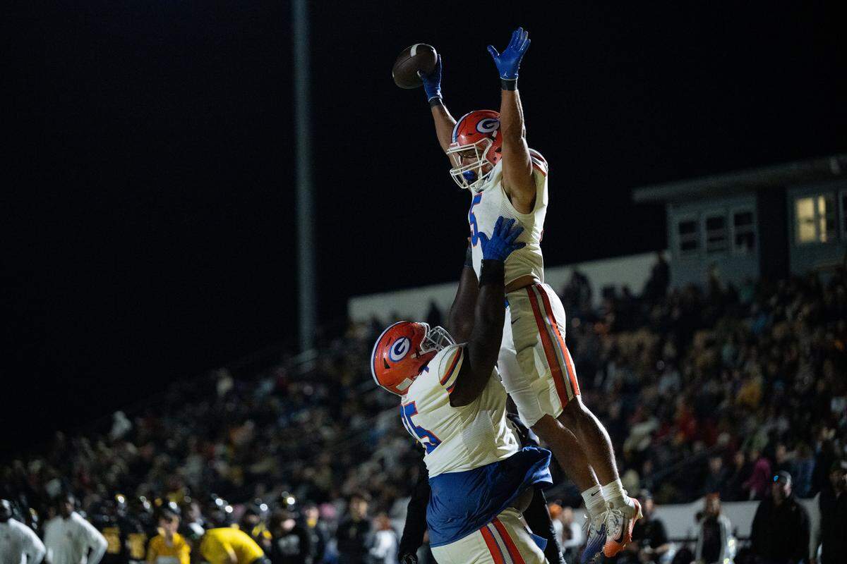 Gulfport running back Cooper Crosby (5) is lifted into the air by offensive lineman Christian Scruggs (75) after scoring a touchdown Friday.