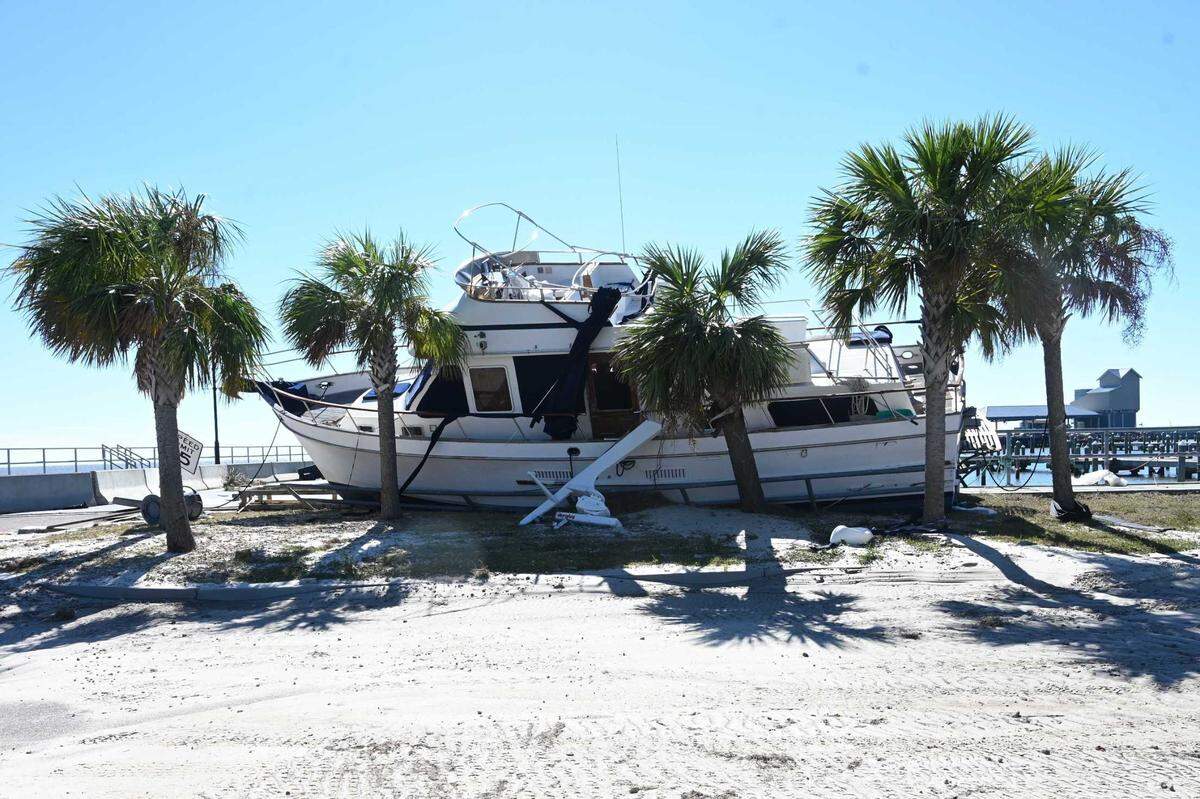 A boat leans against palm trees in Pass Christian Harbor as Hurricane Zeta ripped across the Mississippi Gulf Coast. The Coast harbors will receive funds to mitigate the impact of storms.