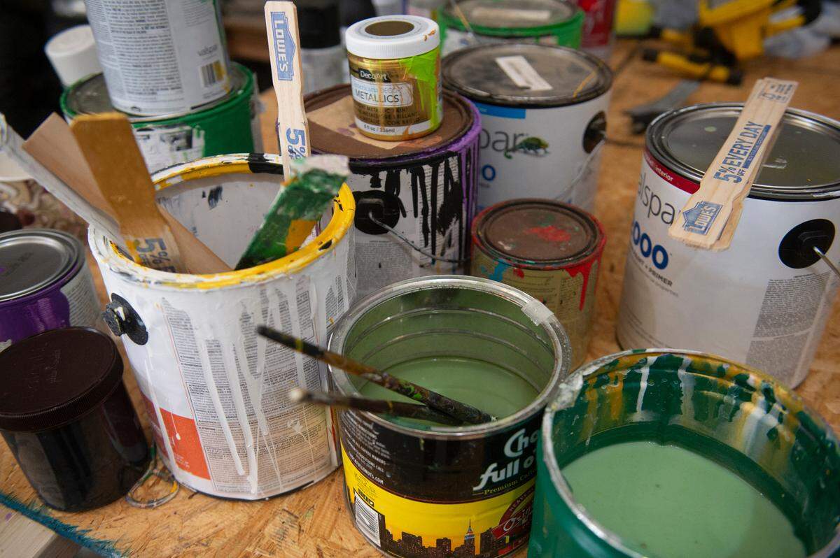 Paint buckets at Gulf Coast Carnival Association Mardi Gras’ Float Den in Biloxi on Wednesday, Jan. 10, 2024. Doug Blom, along with some volunteers, does all the painting, building and designing of the floats.