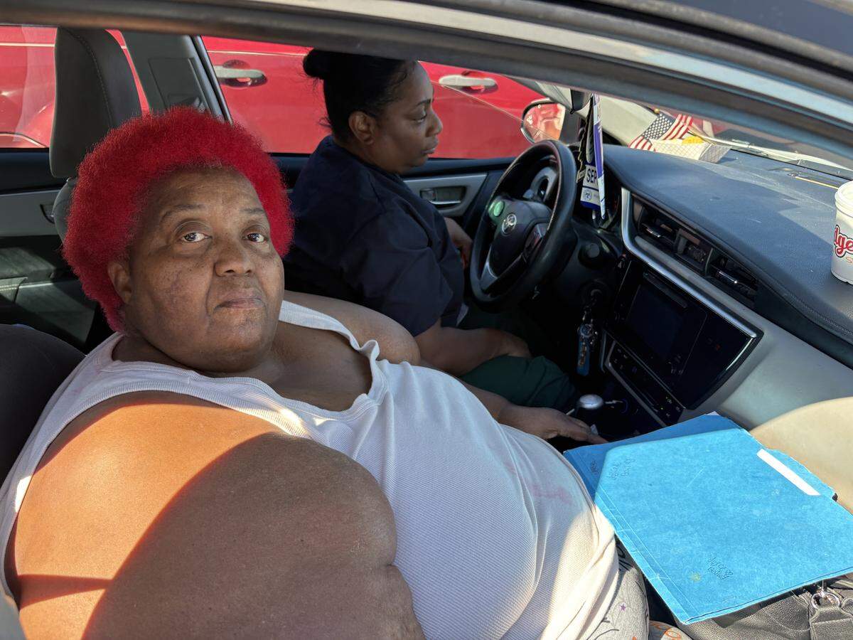 Joyce Bailey, left, and Christina Thomas wait in line Friday at Good Deeds Community Center in Gulfport for a food giveaway. The women, who each have two children, are losing SNAP benefits because of the government shutdown and are concerned about feeding their families. They got in line hours before the giveaway began.