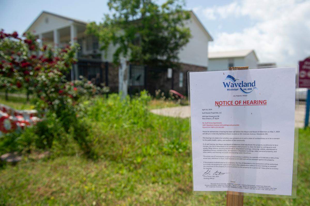 A sign notifying of a hearing stands on the property of the Gulf Grove Apartments in Waveland on Friday, April 19, 2024. The city of Waveland condemned the property over missing roofs, mold, termites and rats and will hold a hearing to determine if the property is a “menace”, which if determined to be so, the city can clean up the property.