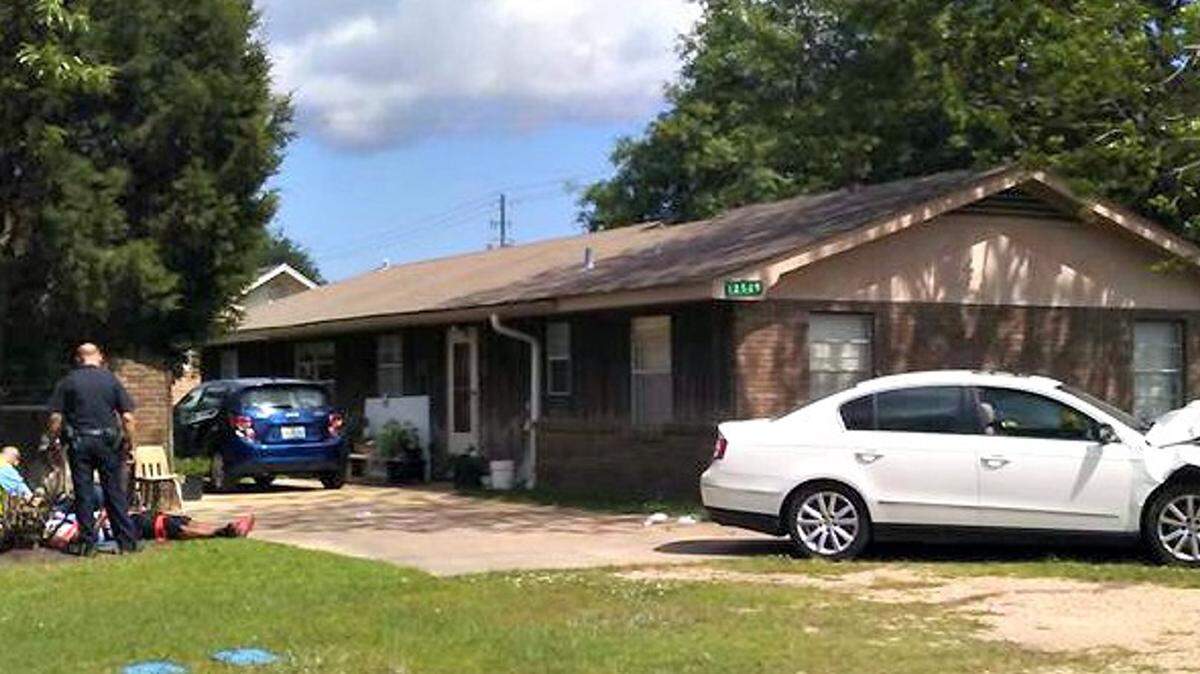 COURTESY MARIE GILL 
 Emergency personnel tend to the suspect in a carjacking on Friday in Gulfport after the driver of the stolen Volkswagen Jetta crashed, nearly hitting a house.