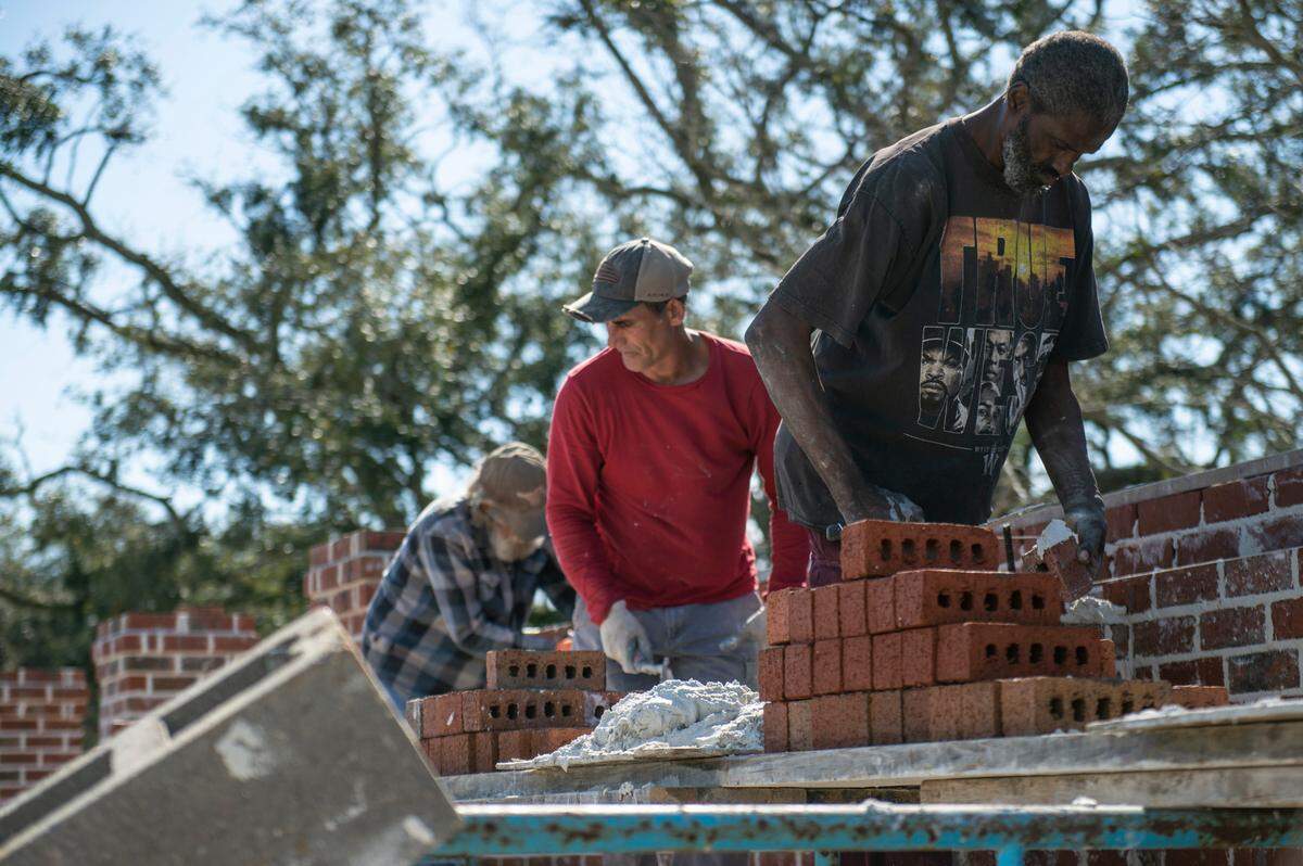Workers hired by Jeffrey Reed’s construction company work on building a brick wall around MLK Park as a part of renovation efforts in the Third Ward in Bay St. Louis on Thursday, March 17, 2022.