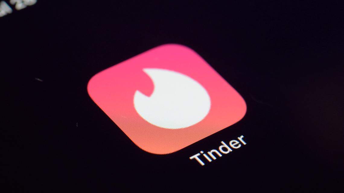 This Tuesday, July 28, 2020 photo shows the icon for the Tinder dating app on a device in New York. The Better Business Bureau is warning consumers about cryptocurrency scams targeting romantic hopefuls on Tinder and other dating apps. (AP Photo/Patrick Sison)