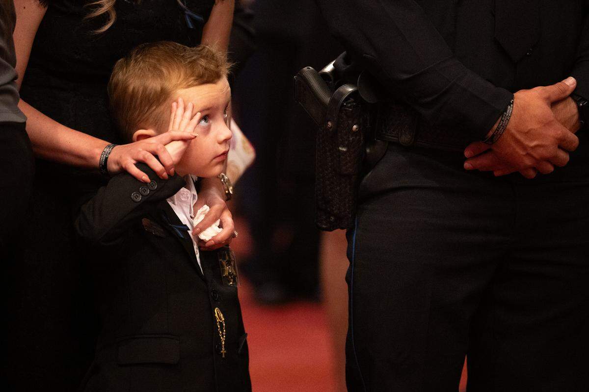 Clayton Powell, grandson of Michael Jimerson, gives a salute to police officers Friday during the funeral for Michael Jimerson at First Baptist Church in Biloxi.