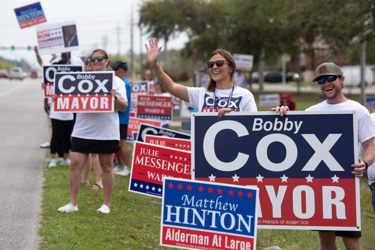 Supporters of Bobby Cox campaign from the roadside at the Civic Center in Ocean Springs during the municipal primary election on Tuesday, April 1, 2025.