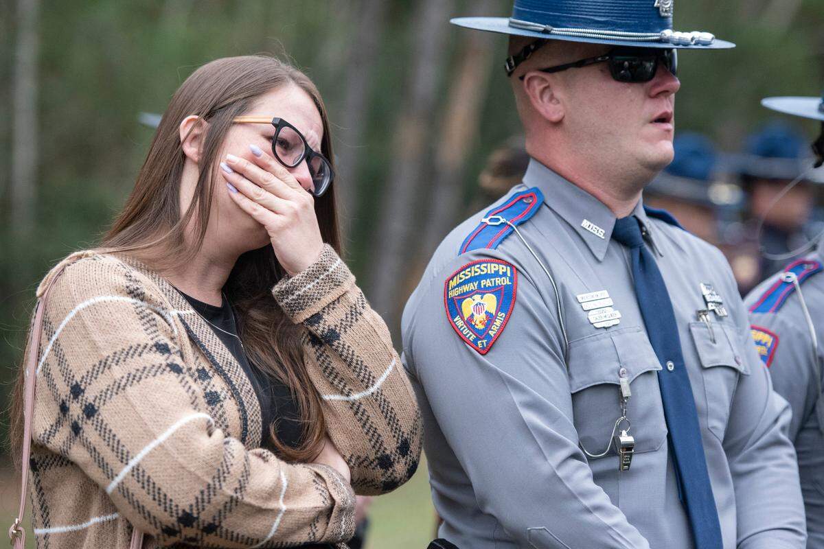Mourners react as Bay St. Louis Capt. Rachel Jewell calls in the last radio call at the gravesite of Bay St. Louis police officers Sgt. Steven Robin and Branden Estorffe at Gardens of Memory cemetery in Bay St. Louis on Wednesday, Dec. 21, 2022. Robin and Estorffe were killed responding to a call at a Motel 6 on Dec. 14.