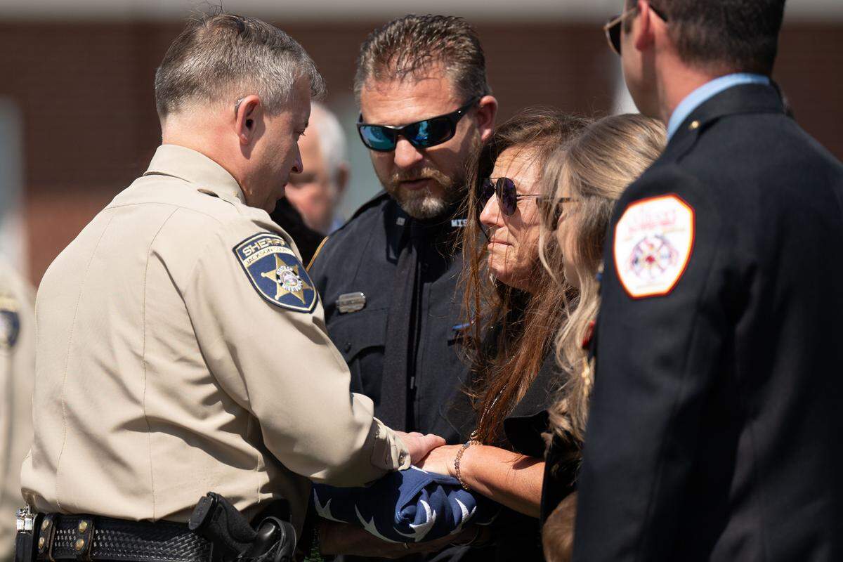 Jackson County Sheriff John Ledbetter presents a trifold flag to Michael Jimerson’s widow, Sheila Jimerson, after his funeral Friday.