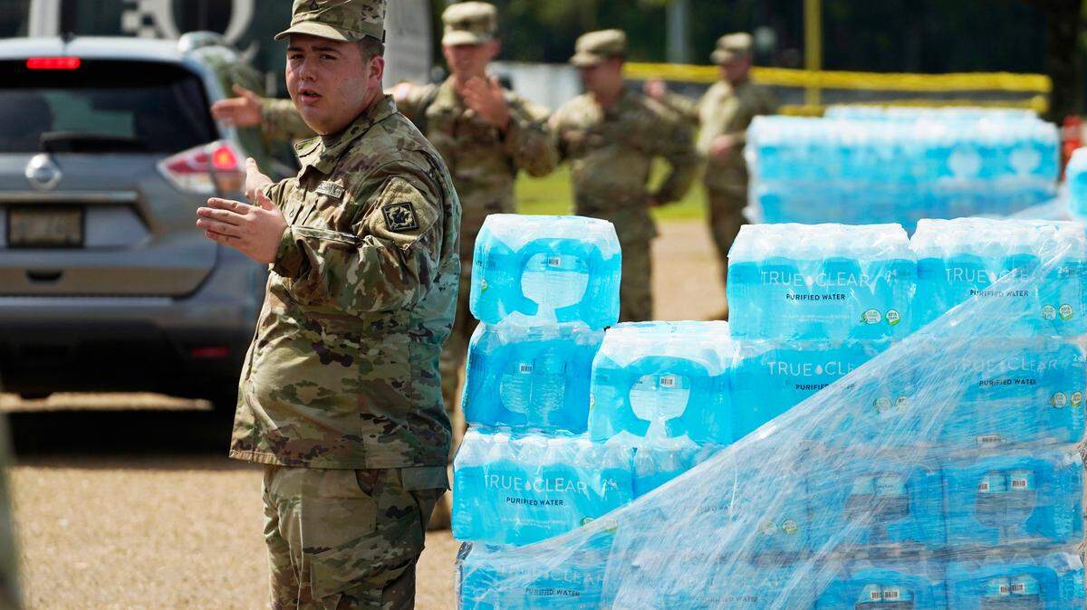 Mississippi National Guardsmen direct traffic as they pass out cases of drinking water to Jackson, Miss., residents, Friday, Sept. 2, 2022, at Smith Wills Stadium. Jackson’s water system partially failed following flooding and heavy rainfall that exacerbated longstanding problems in one of two water-treatment plants, and the state is helping with the distribution of drinking water to the city’s residents. (AP Photo/Rogelio V. Solis)