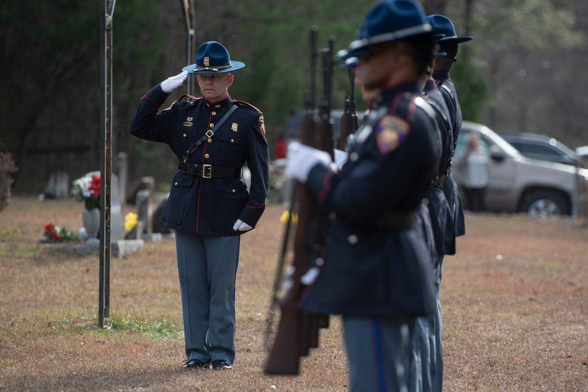 Honor guard salute during a graveside service for George County Sheriff’s Deputy Jeremy Malone at Tanners Cemetery in George County on Friday, Jan. 12, 2024.