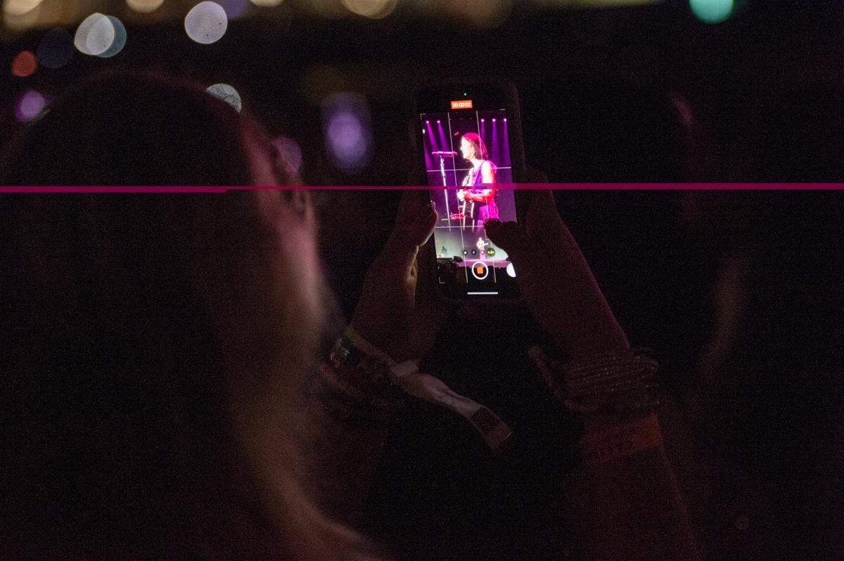 A fan films Gracie Abrams as she performs as the opening act on Taylor Swift’s The Eras Tour at the Cesars Superdome in New Orleans on Friday, Oct. 25, 2024.