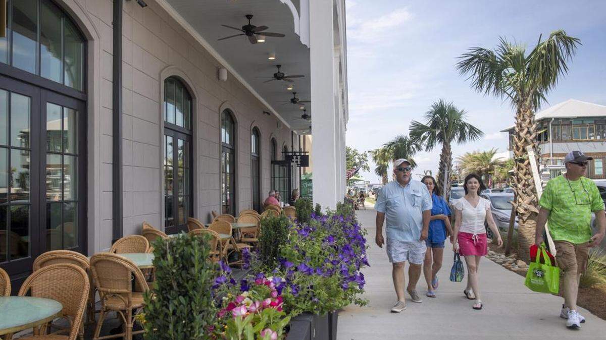 Walking down the sidewalk past the Thorny Oyster restaurant in Bay St. Louis, Mississippi on Friday, May 28, 2021.