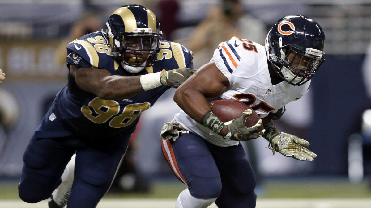 Chicago Bears running back Ka'Deem Carey, right, runs with the ball as St. Louis Rams defensive tackle Nick Fairley defends during the second quarter of an NFL football game Sunday, Nov. 15, 2015, in St. Louis. (AP Photo/Tom Gannam)