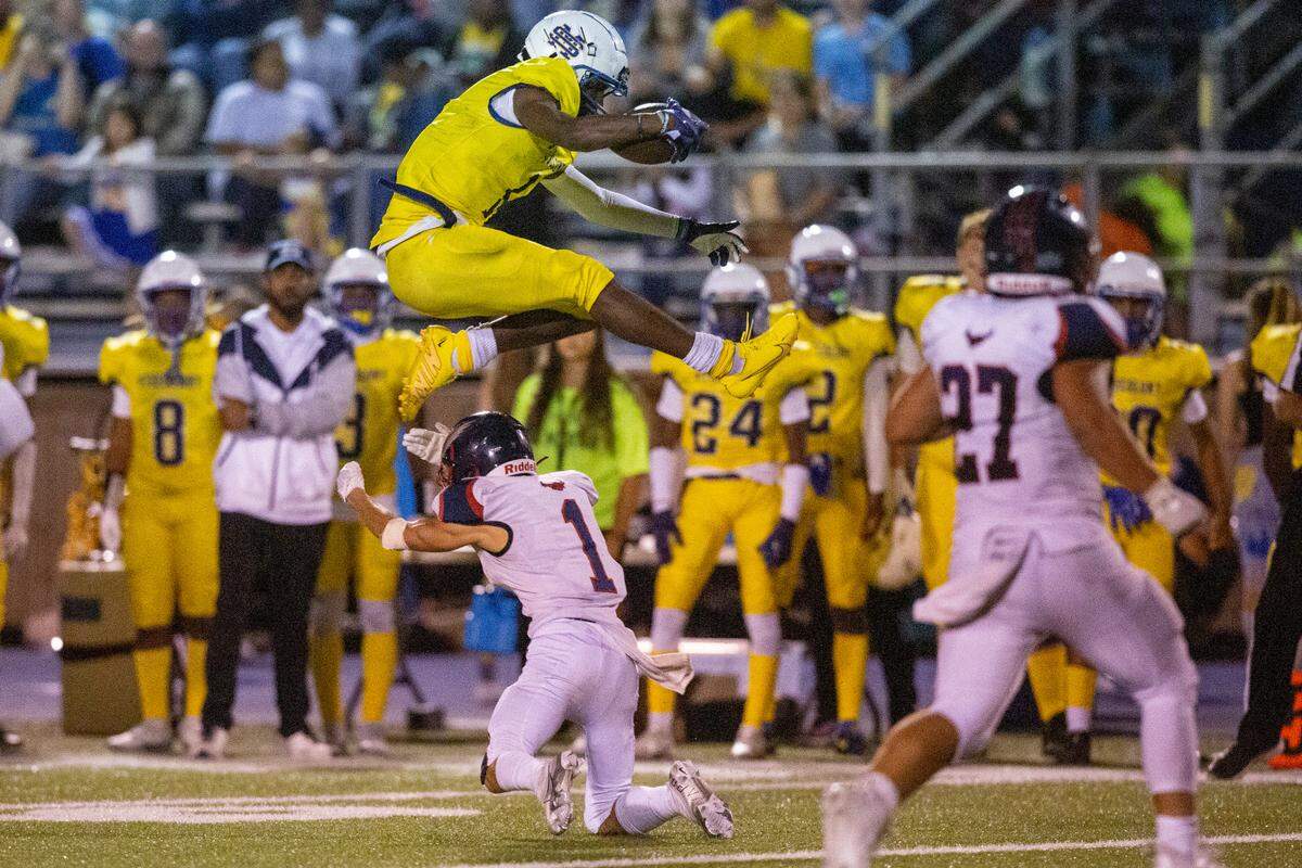 St. Martin’s Noreel White jumps over Hancock’s Coby Kern as he runs the ball down the field during a game against Hancock at Joe Barlow Stadium in St. Martin on Friday, Sept. 30, 2022.