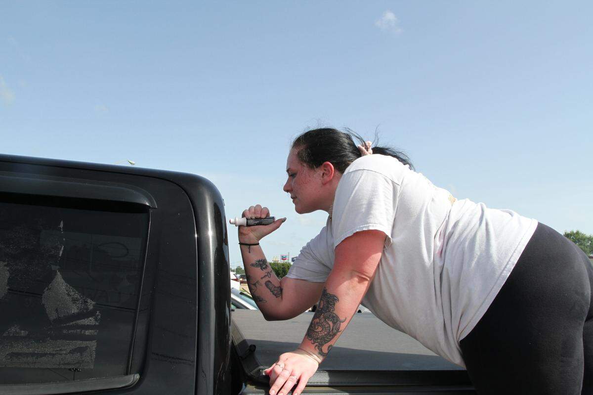Alivia Boccaccio paints symbols of support on a truck’s rear window for the Wyatt family after the death by suicide of 13-year-old Aubreigh Wyatt, whose mother Heather Wyatt says bullying is responsible. Boccaccio is donating proceeds to help with legal fees for Wyatt, who is being sued by the parents of girls who others claim are Aubreigh’s bullies.