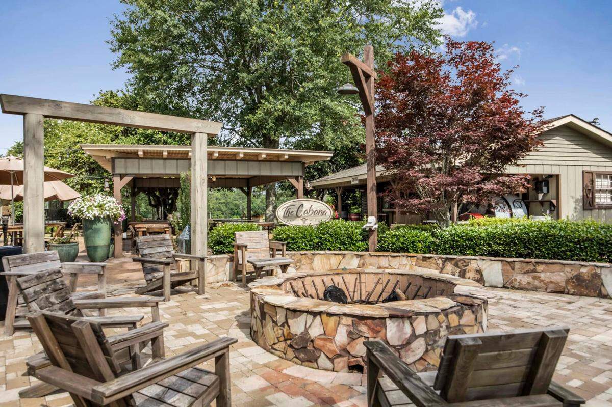 This outdoor seating area at Running Creek Ranch features a fire pit and shows the Cabana Grill. This area includes a commercial smokehouse, grill, bar and seating for 75 guests.