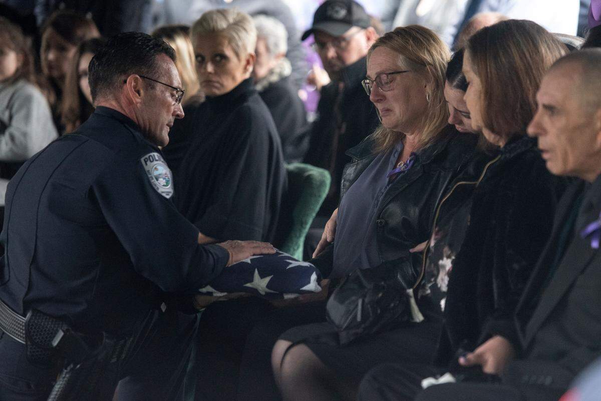 Bay St. Louis Police Chief Toby Schwartz presents a folded flag to Steven Robin’s wife Amy Robin during the funeral of Bay St. Louis police officers Sgt. Steven Robin and Branden Estorffe at Gardens of Memory cemetery in Bay St. Louis on Wednesday, Dec. 21, 2022. Robin and Estorffe were killed responding to a call at a Motel 6 on Dec. 14.