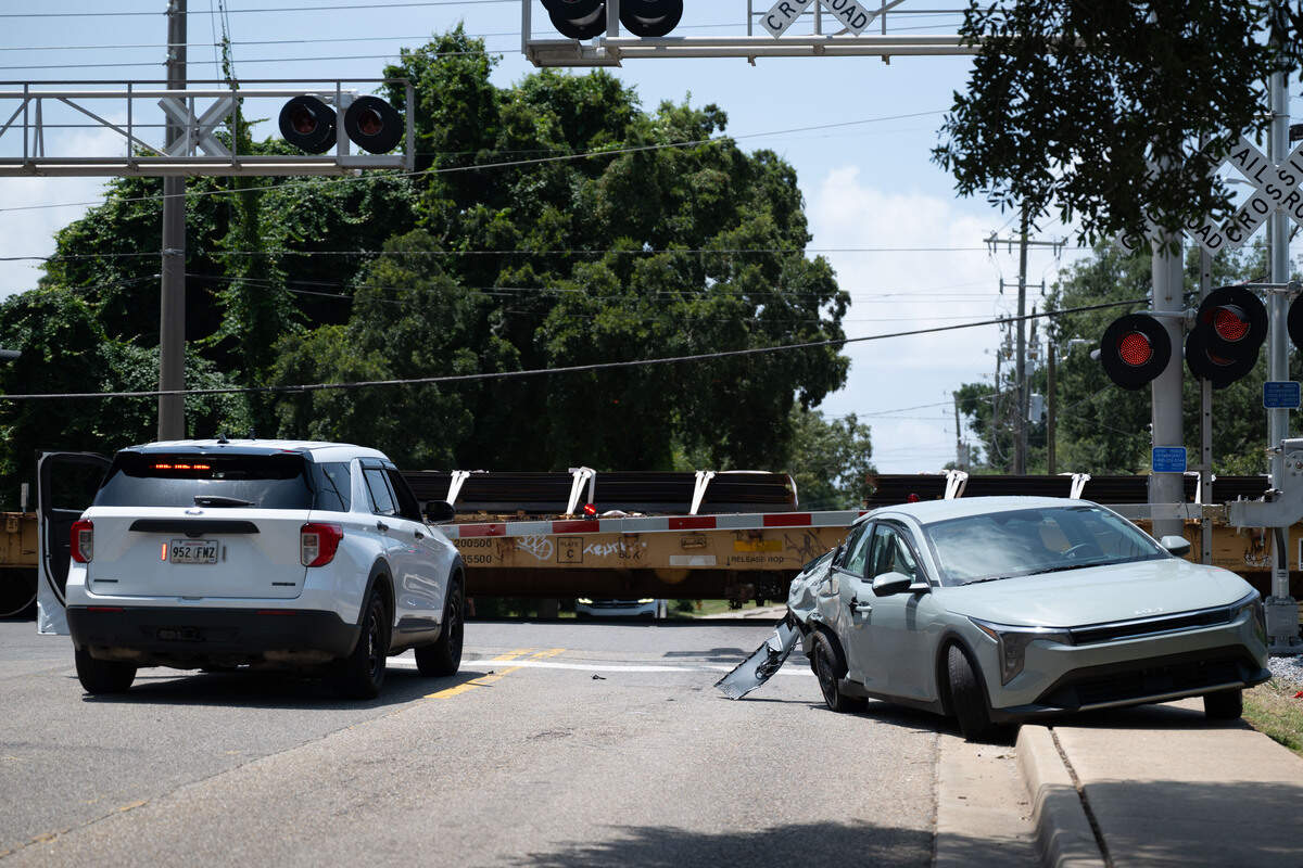 A car is left on the side of the road Friday after it was struck by a train in downtown Biloxi.