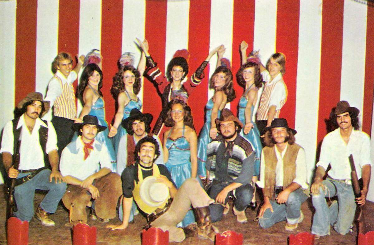 Eight Flags cowboys from Six Gun Junction in Biloxi and the girls working and dancing in the Red Dog Saloon posed on stage for this popular circa 1978 postcard.