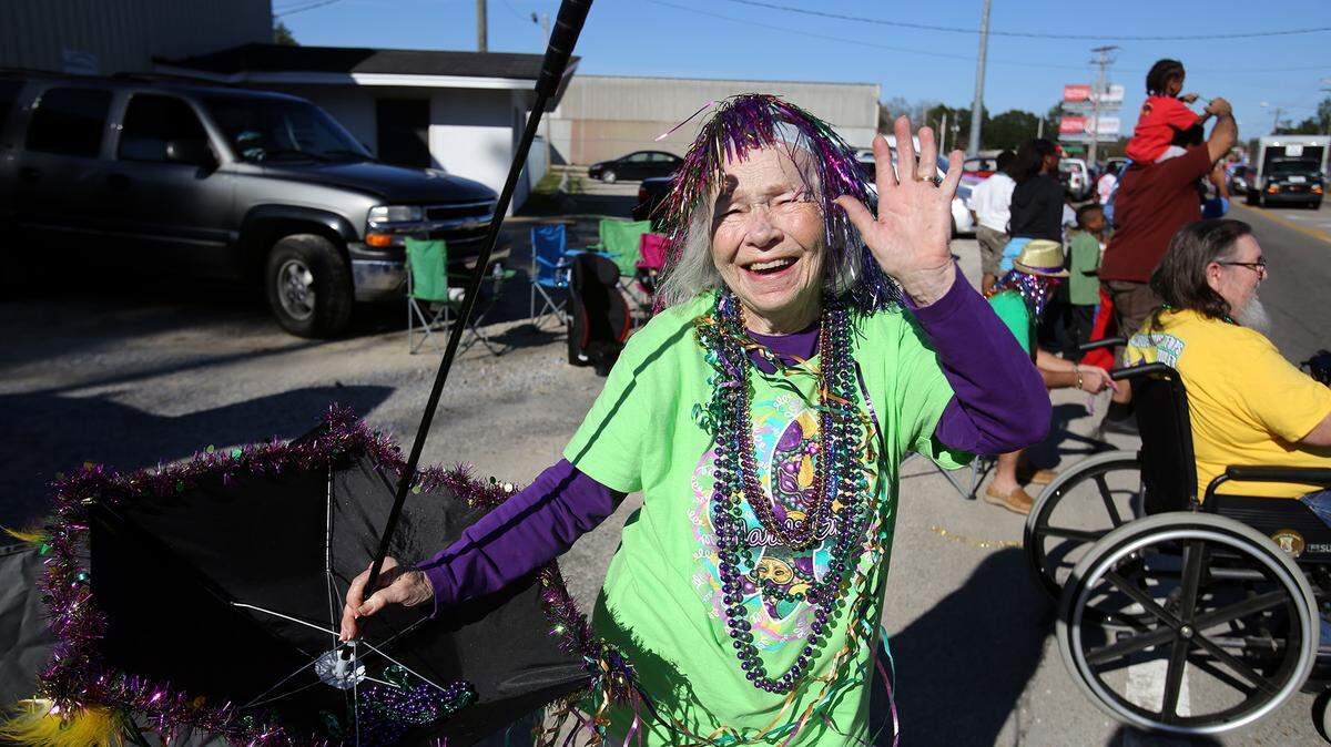 AMANDA McCOY/SUN HERALDMary Ann Hubman, 85, enjoys the 26th annual Orange Grove Carnival Association Mardi Gras parade with her two sons on Saturday in Gulfport.