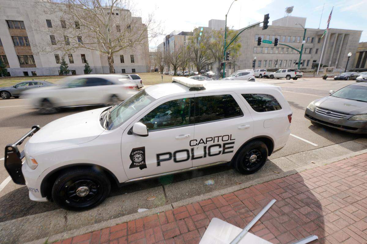 FILE - A Capitol Police SUV is parked across the street from the Hinds County Courthouse, left, and the main offices of the Jackson, Miss., Police Department, right, in downtown Jackson, Miss., Feb. 13, 2023. On Wednesday, Dec. 20, a woman who was shot in the head while she was a passenger in a car fleeing from police filed a federal lawsuit against the Mississippi Department of Public Safety, which oversees the Capitol Police, claiming excessive force. (AP Photo/Rogelio V. Solis, File)