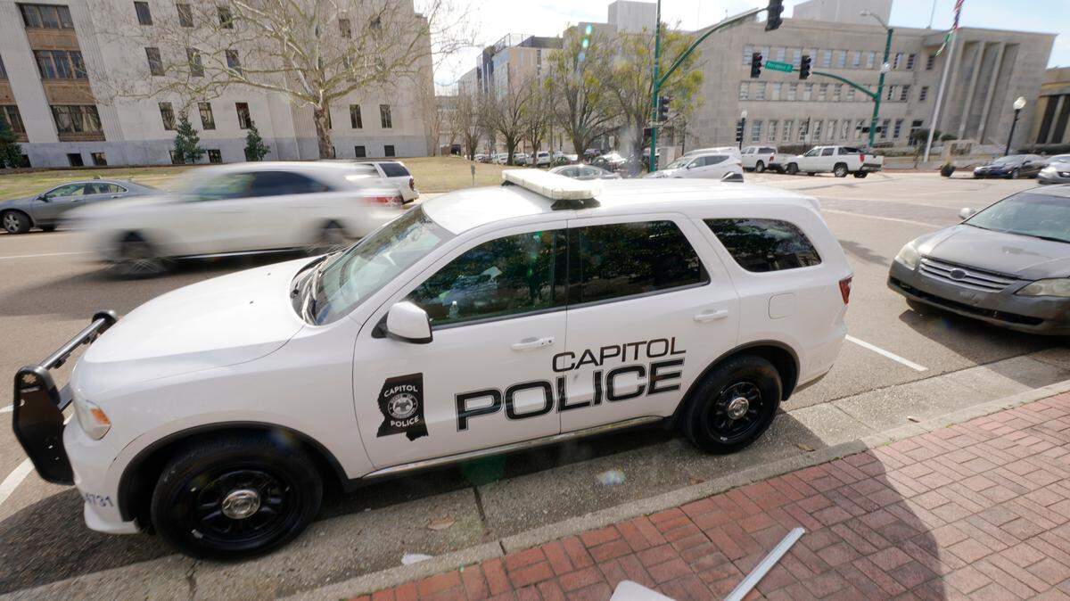 FILE - A Capitol Police SUV is parked across the street from the Hinds County Courthouse, left, and the main offices of the Jackson, Miss., Police Department, right, in downtown Jackson, Miss., Feb. 13, 2023. On Wednesday, Dec. 20, a woman who was shot in the head while she was a passenger in a car fleeing from police filed a federal lawsuit against the Mississippi Department of Public Safety, which oversees the Capitol Police, claiming excessive force. (AP Photo/Rogelio V. Solis, File)