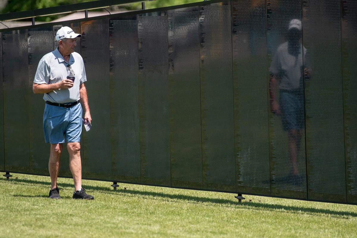 Visitors look at names on The Wall That Heals, a traveling three-quarter scale replica of the Vietnam Veterans Memorial in D.C., while it is on display at the D’Iberville Sports Complex in D’Iberville on Thursday, April 10, 2025.