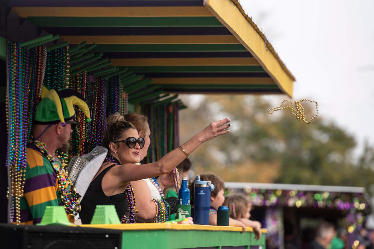 A float rider throws beads during The Ocean Springs Elks Carnival Parade in downtown Ocean Springs on Saturday, Jan. 27, 2024.