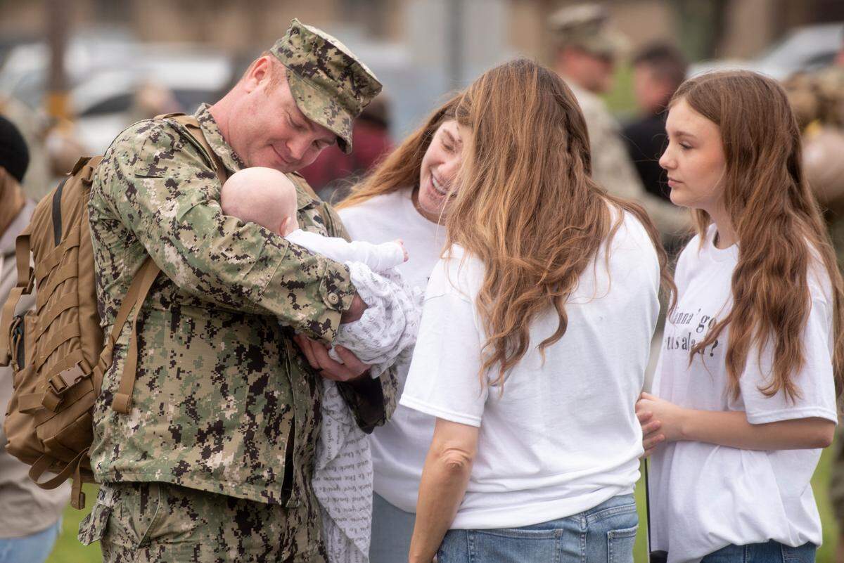 James Pinkston, a member of Naval Mobile Construction Battalion 133, holds his newborn baby Elizabeth as he reunites with his family after returning from deployment at a homecoming event at the Naval Construction Battalion Center in Gulfport on Tuesday, March 5, 2024. Pinkston’s newborn was born while he was deployed.