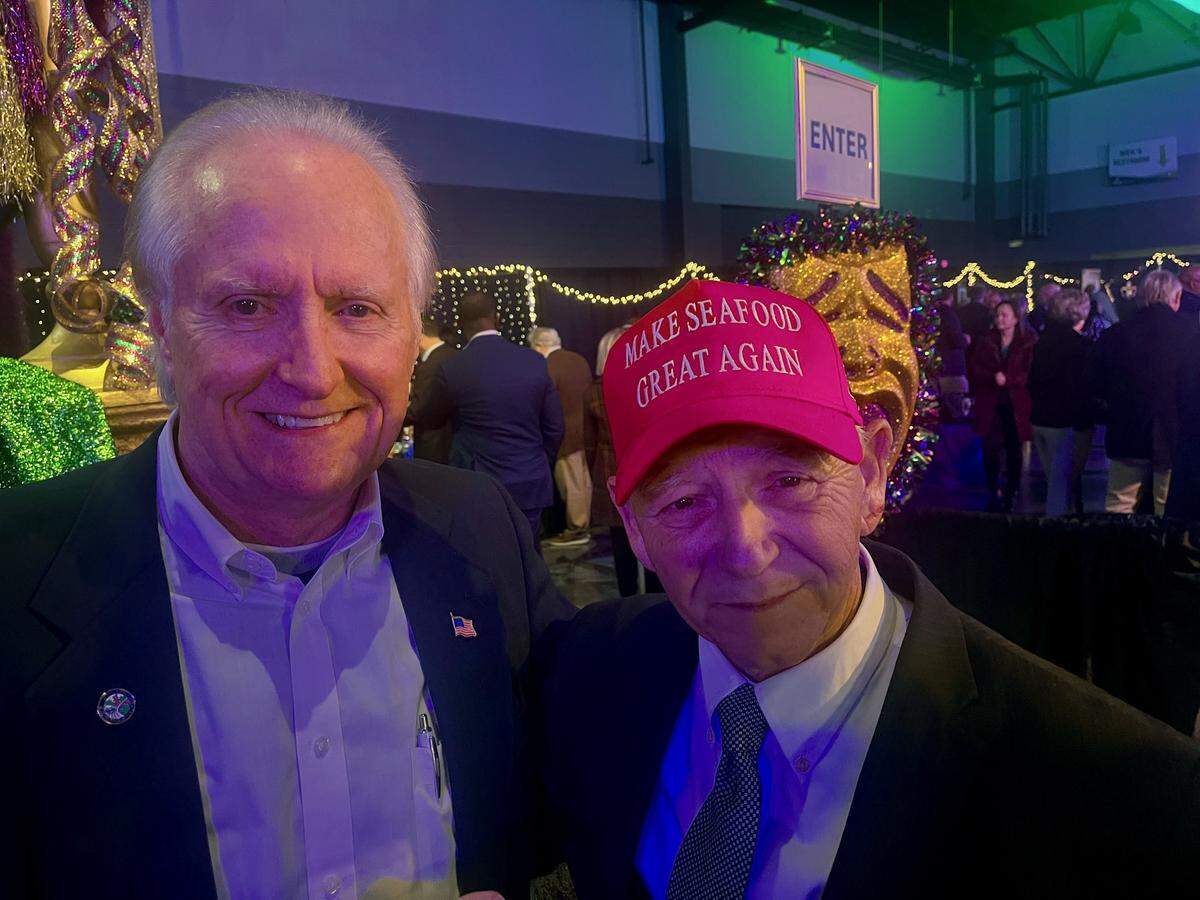 D’Iberville Mayor Rusty Quave, right, wears one of caps the Mississippi Department of Marine Resources ordered to promote Gulf seafood at a Mississippi Coast legislative reception Wednesday night. He’s pictured with retired state agency employee Jim Walker, who said that he wished he had gotten a cap before they were all gone.