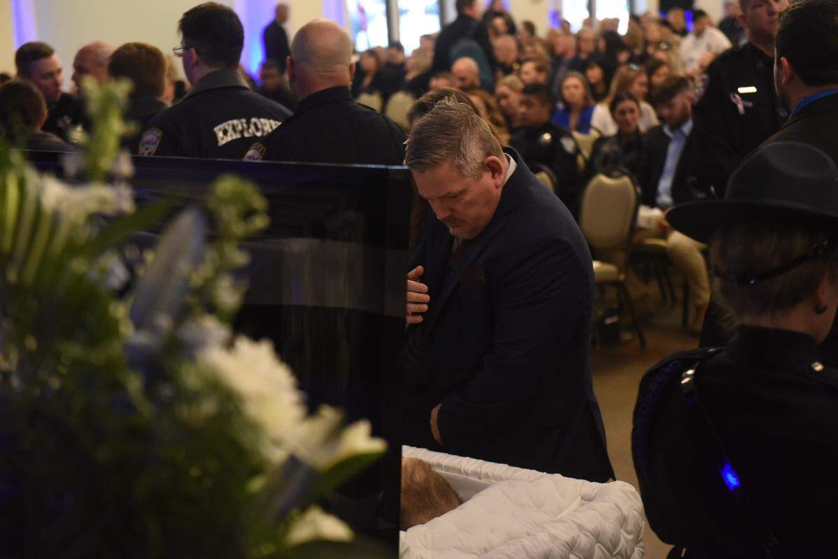 A man pays respects to fallen officers Branden Estorffe and Steven Robin on Dec. 21, 2022, at a joint funeral service in Bay St. Louis.