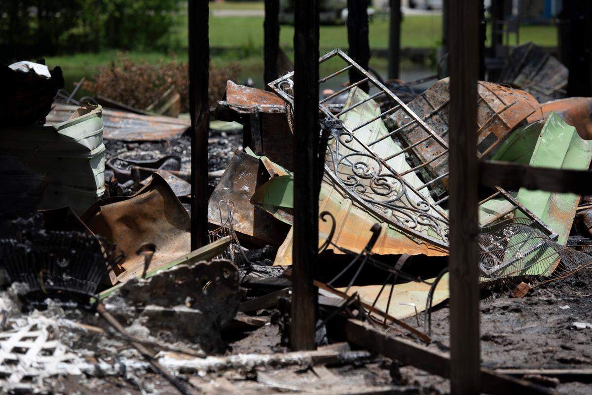 Metal fences and debris remain on a property on Highway 603 in the Kiln on Tuesday, May 31, 2022. On Saturday night, a fire tore through the property and the adjacent house, killing two.