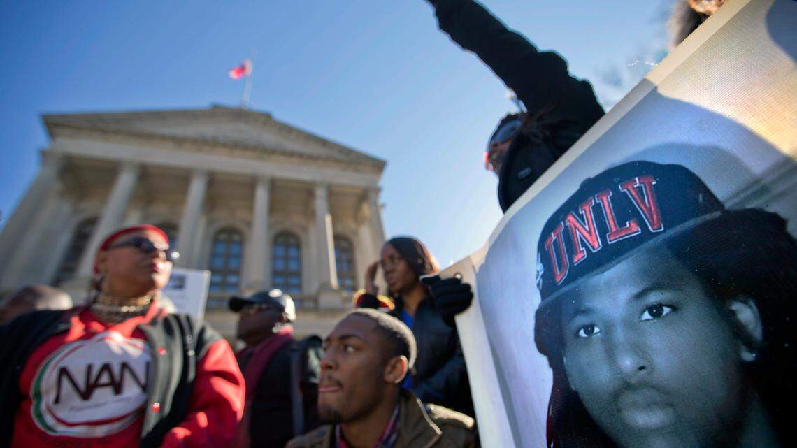 An image of Kendrick Johnson, the south Georgia teenager officials said was found dead inside a rolled-up wrestling mat in his school, is displayed on a banner, as demonstrators attend a “Who Killed K.J.” rally in Atlanta. (AP Photo/David Goldman)