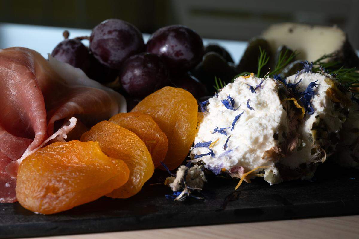 French chèvre sprinkled with wildflowers and sliced apricots are featured on a charcuterie board at St. James Cheese Company in Pass Christian.