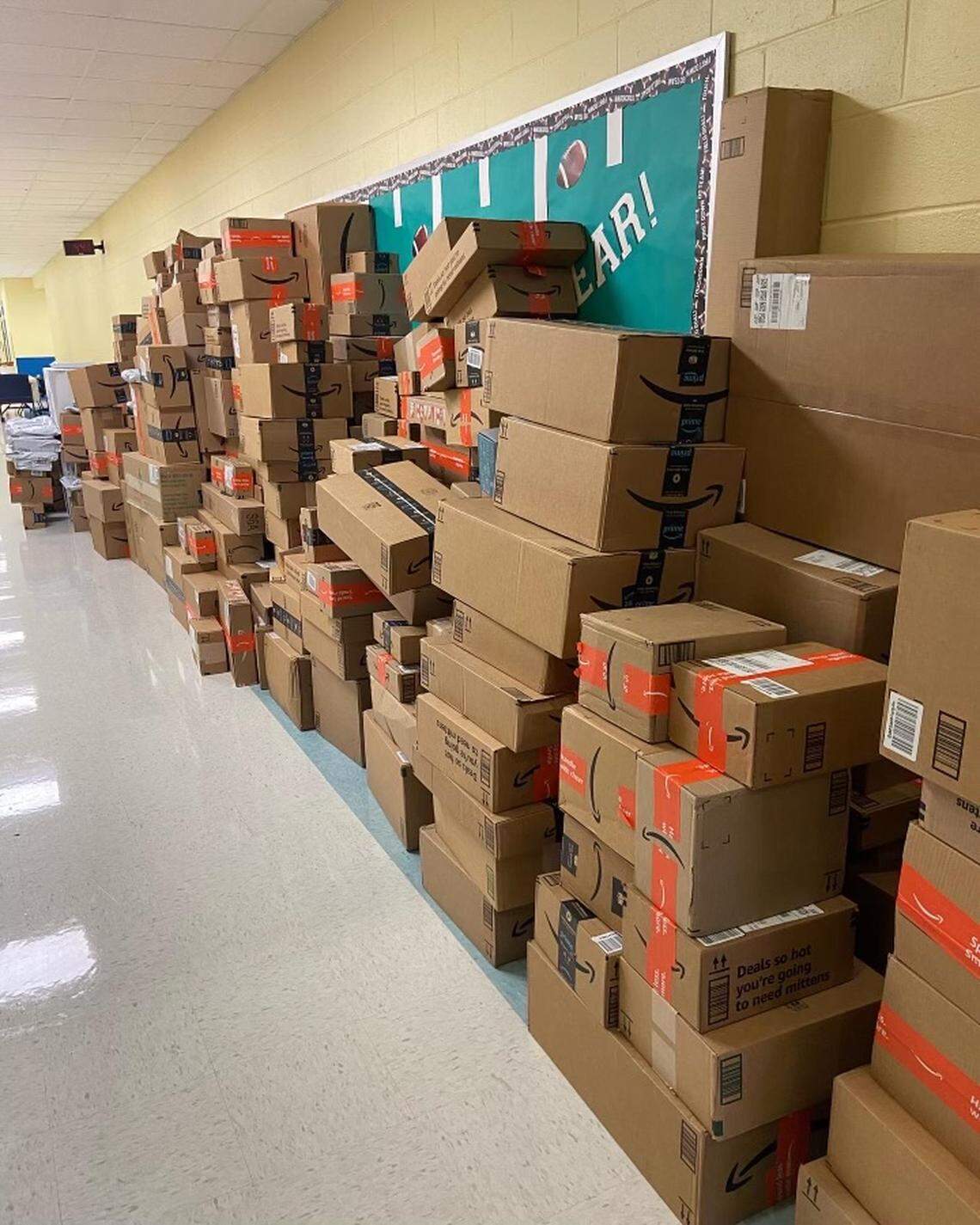 Packages received from Caroline Davis’s Christmas wish list to support Hancock County school children lining a school building hallway.